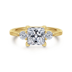 Gabriel & Co. ER16475S6Y44JJ 14 karat yellow gold Classic engagement ring, front view of four corner prongs with pyramid tips around a princess cut center and round side stones