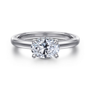 Gabriel & Co. ER16476O4W44JJ 14 karat white gold Classic engagement ring, front view of an oval center set sideways with diamonds peeking out behind it