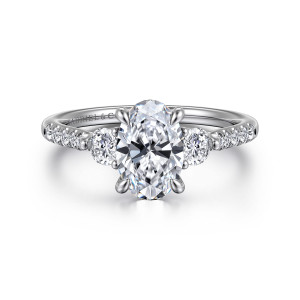 Gabriel & Co. ER16487O6W44JJ 14 karat white gold Lotus engagement ring, front view of an oval center beside two larger round diamonds with small stones running down the shoulders