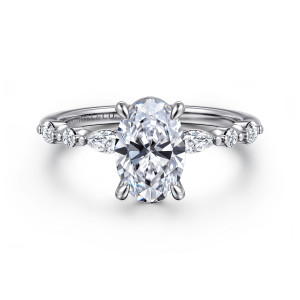 Gabriel & Co. ER16497O6W44JJ 14 karat white gold Contemporary engagement ring, front view of an oval center on four prongs with mixed stones spaced along the thin band