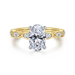 Gabriel & Co. ER16505O6M44JJ 14 karat white and yellow gold Contemporary engagement ring, front view of an oval center beside elongated diamonds held in crossing ribbon loops
