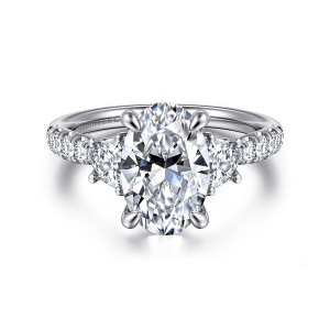 Gabriel & Co. ER16507O10W44JJ 14 karat white gold Lotus engagement ring, front view of an oval center with four prongs between larger side stones