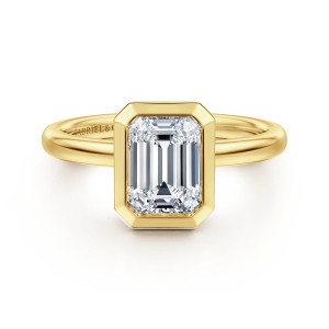 Gabriel & Co. ER16526E6Y4JJJ 14 karat yellow gold Contemporary engagement ring, front view of a bezel with clipped corners framing an emerald cut center on a rounded band