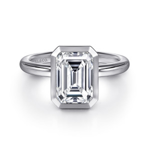 Gabriel & Co. ER16526E8W4JJJ 14 karat white gold Contemporary engagement ring, front view of an emerald cut center inside a smooth bezel with clipped corners
