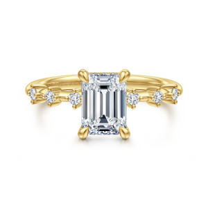 Gabriel & Co. ER16530E6Y44JJ 14 karat yellow gold Starlight engagement ring, front view of the emerald cut center between teardrop prongs with spaced round diamonds along each shoulder