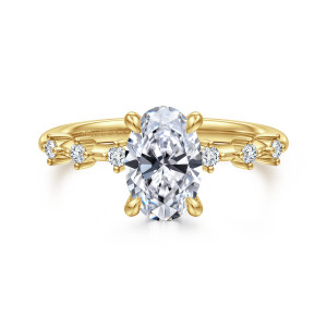 Gabriel & Co. ER16530O6Y44JJ 14 karat yellow gold Starlight engagement ring, front view of an oval center flanked by round diamonds set apart in tiny prong settings