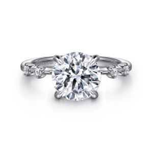 Gabriel & Co. ER16530R12W44JJ 14 karat white gold Starlight engagement ring, front view of a round center on claw prongs with separate small diamonds on each shoulder