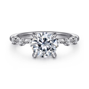 Gabriel & Co. ER16530R6W44JJ 14 karat white gold Starlight engagement ring, front view of a round center with curved claw prongs and diamonds spaced along each shoulder