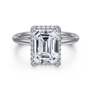 Gabriel & Co. ER16565E12W44JJ 14 karat white gold Contemporary engagement ring, front view of an emerald cut center with corner claws and tiny diamonds peeking out along its edges
