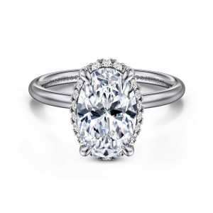 Gabriel & Co. ER16565O10W44JJ 14 karat white gold Contemporary engagement ring, front view of an oval center with small diamonds showing around its base and a smooth band