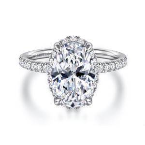 Gabriel & Co. ER16566O12W44JJ 14 karat white gold Contemporary engagement ring, front view of an oval center with a thin rim of halo stones and diamonds along the band
