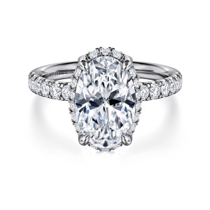 Gabriel & Co. ER16568O12W44JJ 14 karat white gold Contemporary engagement ring, front view of an oval center with halo stones peeking around its rim and four claw prongs