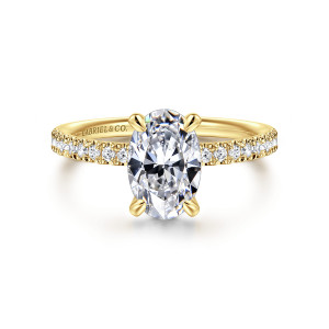 Gabriel & Co. ER16570O6Y44JJ 14 karat yellow gold Contemporary engagement ring, front view of an oval center held by four claw prongs above small round diamonds along the shoulders
