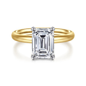 Gabriel & Co. ER16571E10M4JJJ 14 karat white and yellow gold Contemporary engagement ring, front view of the emerald cut center in four corner prongs on a smooth rounded band