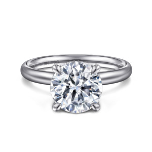 Gabriel & Co. ER16622R10W44JJ 14 karat white gold Classic engagement ring, front view of a round center in four claw prongs on a smooth band with a maker's mark