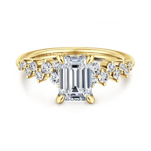 Gabriel & Co. ER16665E6Y44JJ 14 karat yellow gold Starlight engagement ring, front view of an emerald cut center in four prongs with staggered round diamonds on both shoulders