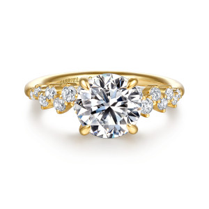 Gabriel & Co. ER16665R8Y44JJ 14 karat yellow gold Starlight engagement ring, front view of a round center flanked by mixed size stones stepping down each shoulder