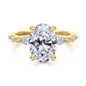 Gabriel & Co. ER16666O12Y44JJ 14 karat yellow gold Starlight engagement ring, front view of an oval center in four claws with elongated and round stones spaced along the band