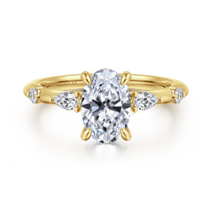 Gabriel & Co. ER16666O6Y44JJ 14 karat yellow gold Starlight engagement ring, front view of an oval center with elongated and round diamonds spaced along the shoulders