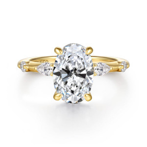 Gabriel & Co. ER16666O8Y44JJ 14 karat yellow gold Bujukan engagement ring, front view of an oval center with an elongated diamond and a round one on each side