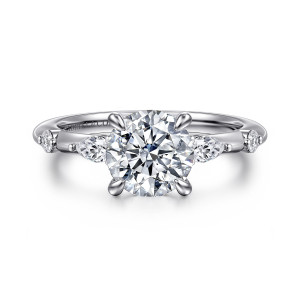 Gabriel & Co. ER16666R6W84JJ 18 karat white gold Starlight engagement ring, front view of a round center flanked by elongated and round small stones on a slim band