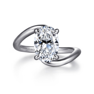Gabriel & Co. ER16667O8W44JJ 14 karat white gold Contemporary engagement ring, front view of an oval center held by claw prongs between the passing ends of the smooth band