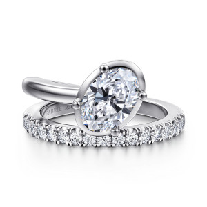 Gabriel & Co. ER16668O6W44JJ 14 karat white gold Contemporary engagement ring, front view of an oval center tilted inside a smooth rim above a row of round diamonds