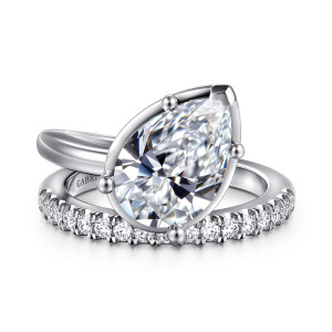 Gabriel & Co. ER16668P12W44JJ 14 karat white gold Contemporary engagement ring, front view of a pear shaped center on ball tipped prongs beside a row of round diamonds