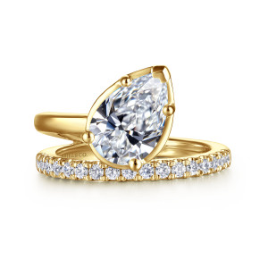 Gabriel & Co. ER16668P8Y44JJ 14 karat yellow gold Bujukan engagement ring, front view of a slanted pear center with ball tipped prongs beside the smooth band arm