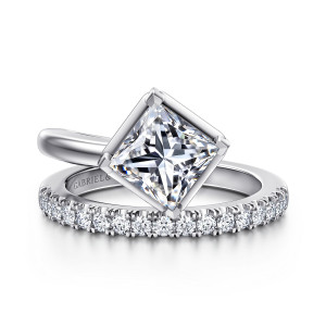 Gabriel & Co. ER16668S6W44JJ 14 karat white gold Contemporary engagement ring, front view of the plain end and the diamond set end passing beside the diagonal princess cut center