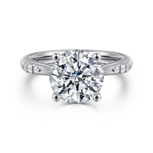 Gabriel & Co. ER16670R12W44JJ 14 karat white gold Contemporary engagement ring, front view of a round center in four ball tipped prongs beside small shoulder clusters