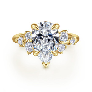 Gabriel & Co. ER16684P12Y44JJ 14 karat yellow gold Starlight engagement ring, front view of a pear shaped center with tapered prongs and round stone clusters on both shoulders