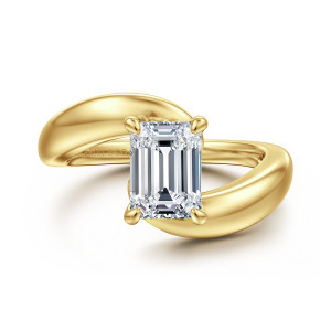 Gabriel & Co. ER16698E6Y4JJJ 14 karat yellow gold Contemporary engagement ring, front view of an emerald cut center with the band ends sweeping past each side of the head
