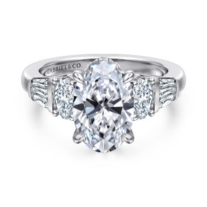 Gabriel & Co. ER16701O12W44JJ 14 karat white gold Contemporary engagement ring, front view of the oval center beside oval side diamonds and tapered baguettes on both shoulders