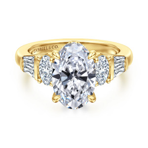 Gabriel & Co. ER16701O12Y44JJ 14 karat yellow gold Contemporary engagement ring, front view of the oval center between larger side stones with tapered baguettes beyond