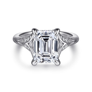 Gabriel & Co. ER16704E12W44JJ 14 karat white gold Contemporary engagement ring, front view of an emerald cut center between the diamond set wings of the split shank