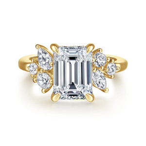 Gabriel & Co. ER16706E12Y44JJ 14 karat yellow gold Starlight engagement ring, front view of the emerald cut center with uneven clusters of round and elongated diamonds