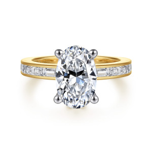 Gabriel & Co. ER16753O10M44JJ 14 karat white and yellow gold Classic engagement ring, front view of an oval center on ball tipped prongs above a channel of baguette diamonds