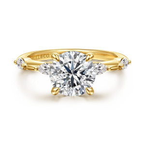 Gabriel & Co. ER16831R8Y43JJ 14 karat yellow gold Starlight engagement ring, front view of a round center flanked by elongated diamonds lying lengthwise on the band