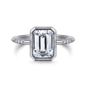 Gabriel & Co. ER16857E10W44JJ 14 karat white gold Contemporary engagement ring, front view of the clipped corner bezel around the emerald cut center with clusters on each shoulder