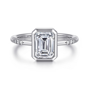 Gabriel & Co. ER16857E6W44JJ 14 karat white gold Contemporary engagement ring, front view of an emerald cut center in a clipped corner bezel with stone clusters beside it