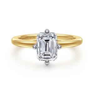 Gabriel & Co. ER16858E6M4JJJ 14 karat white and yellow gold Contemporary engagement ring, front view of an emerald cut center held by pointed prongs at the middle of each side