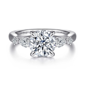 Gabriel & Co. ER16894R8W44JJ 14 karat white gold Lotus engagement ring, front view of a round center flanked by elongated and small round shoulder diamonds