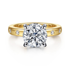 Gabriel & Co. ER16898R12M44JJ 14 karat white and yellow gold Contemporary engagement ring, front view of a round center on four tapered prongs with flush bezel stones at the band sides
