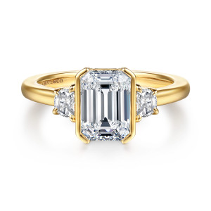 Gabriel & Co. ER16908E8Y43JJ 14 karat yellow gold Contemporary engagement ring, front view of metal walls along the sides of an emerald cut center between two side diamonds