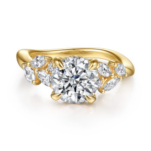 Gabriel & Co. ER16910R8Y44JJ 14 karat yellow gold Floral Nouveau engagement ring, front view of the round center between leaf shaped clusters of small elongated diamonds