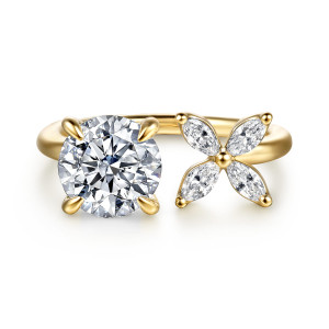 Gabriel & Co. ER16937R8Y44JJ 14 karat yellow gold Contemporary engagement ring, front view of a round center held by four prongs beside a flower of elongated diamonds