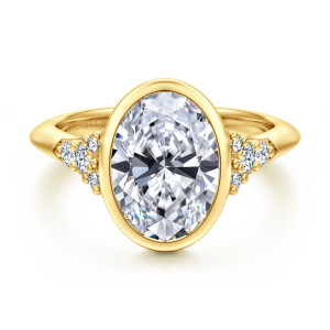 Gabriel & Co. ER16998O12Y44JJ 14 karat yellow gold Contemporary engagement ring, front view of an oval center in a full bezel with diamond clusters at each shoulder