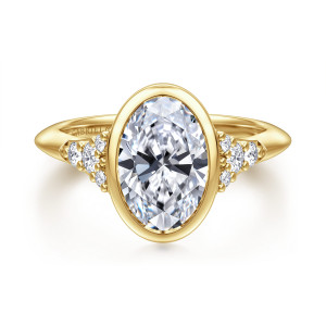 Gabriel & Co. ER16998O8Y44JJ 14 karat yellow gold Contemporary engagement ring, front view of an oval center in a smooth bezel with diamond clusters on each pointed shoulder