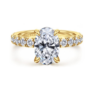 Gabriel & Co. ER17003O8Y44JJ 14 karat yellow gold Classic engagement ring, front view of an oval center held by four teardrop tipped prongs above a diamond lined band